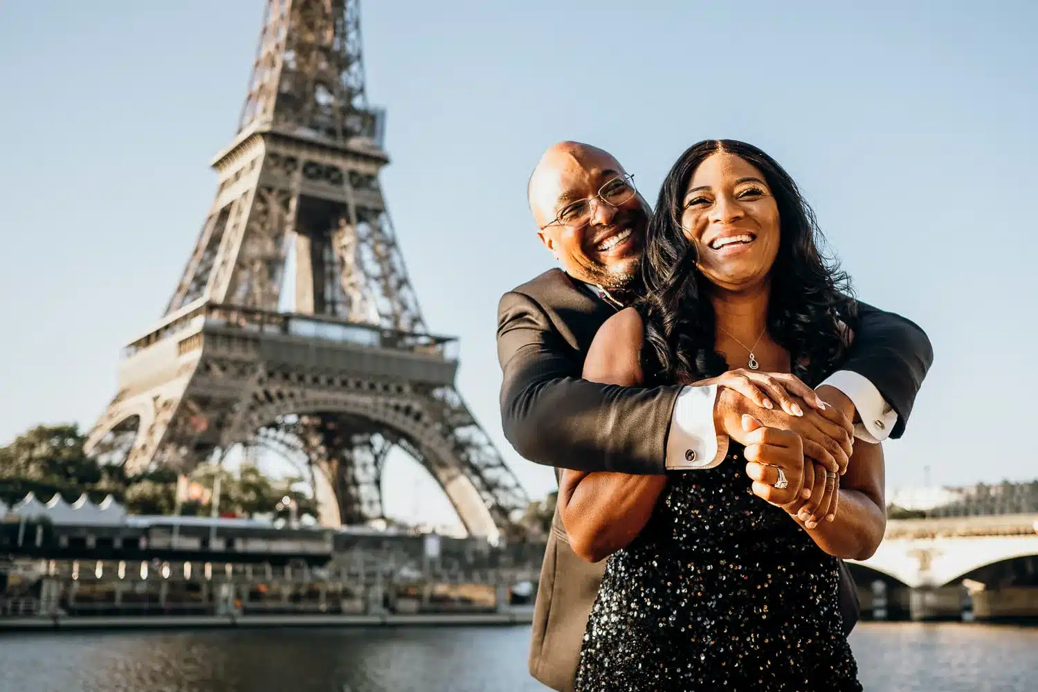 Couple sitting on a bench facing the Eiffel Tower during a romantic sunset in Paris
